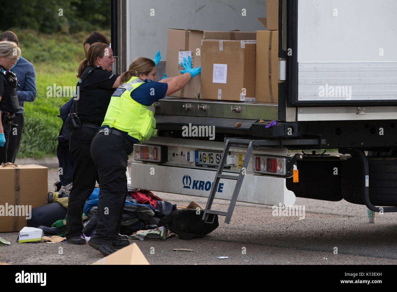 Police officers and search teams go through boxes found in a lorry where 13 men and boys, including a 15-year-old, were discovered, at the Mangrove Service Station, on the A45 London Road, in Rugby, Warwickshire. Stock Photo
