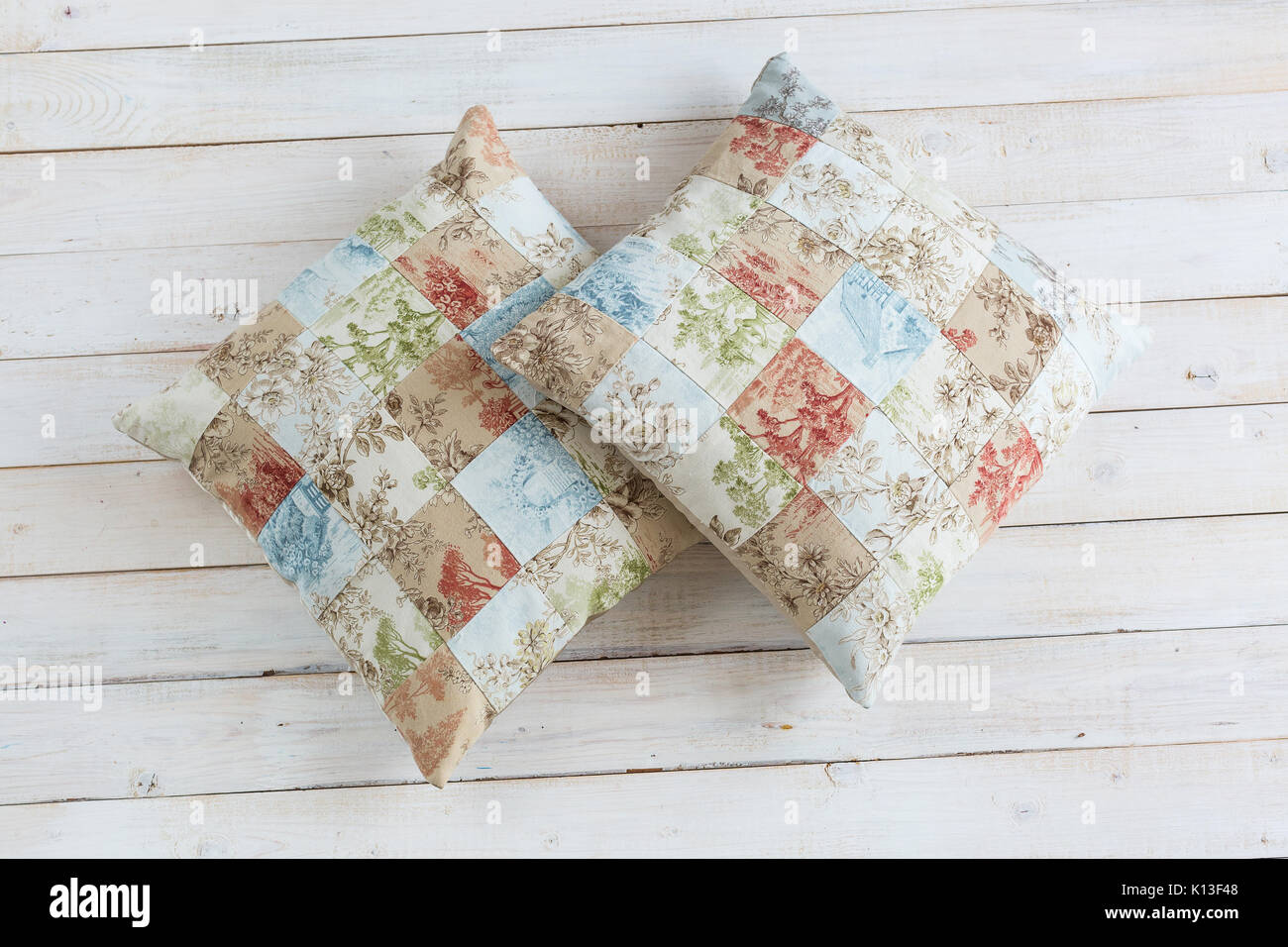 home, rest, hobby concept. two plumpy cosy pillows in pillowcases with exsquisite print consist of many square zones and prints of threes, flowers and Stock Photo