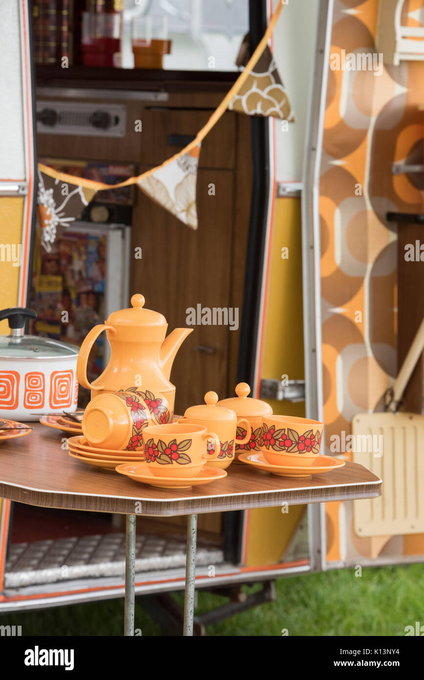 1970s coffee pot and cups on a table outside a vintage caravan at a vintage retro festival. UK Stock Photo