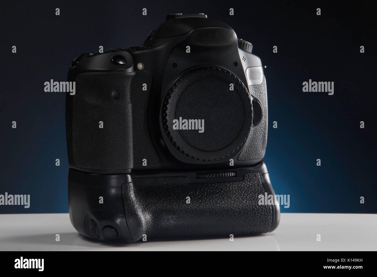 A Modern DSLR camera with Lens cap and battery grip attached Stock Photo
