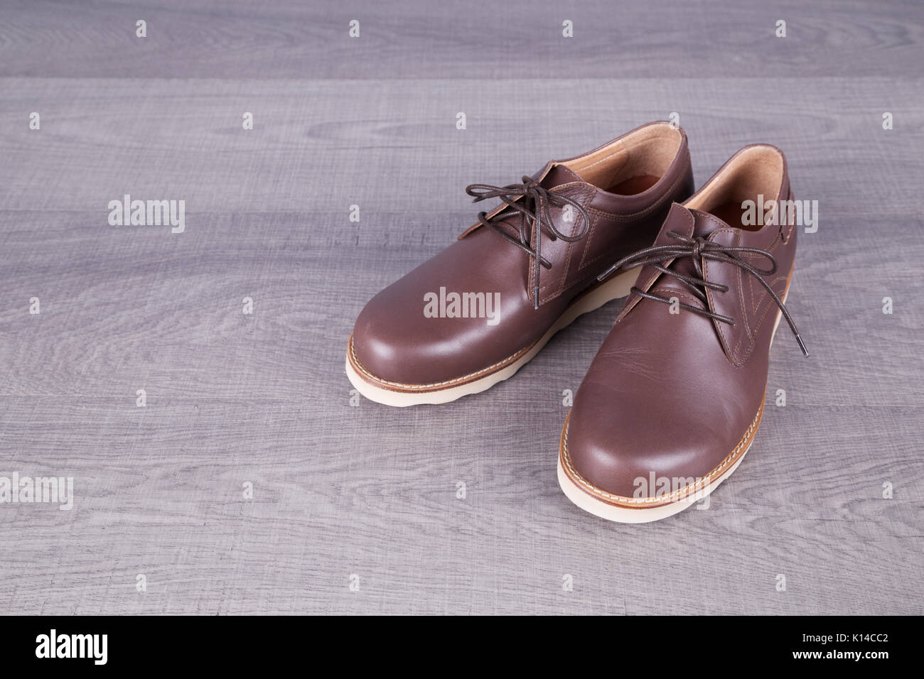 Brown leather men's shoes on a wood background Stock Photo - Alamy