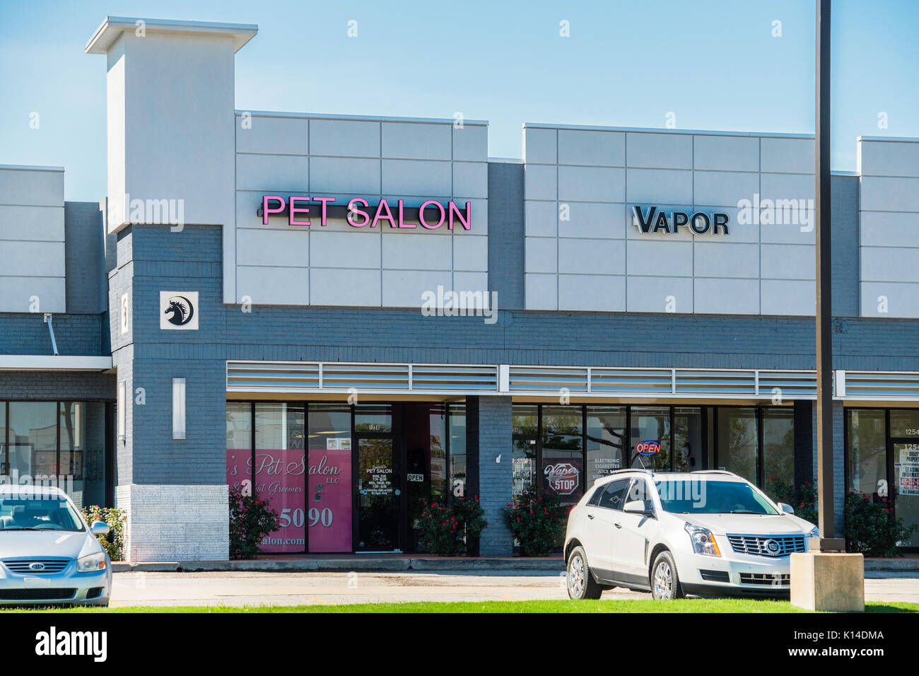 Exterior storefronts of a Pet Salon and a Vapor shop in a strip mall in Norman, Oklahoma, USA. Stock Photo