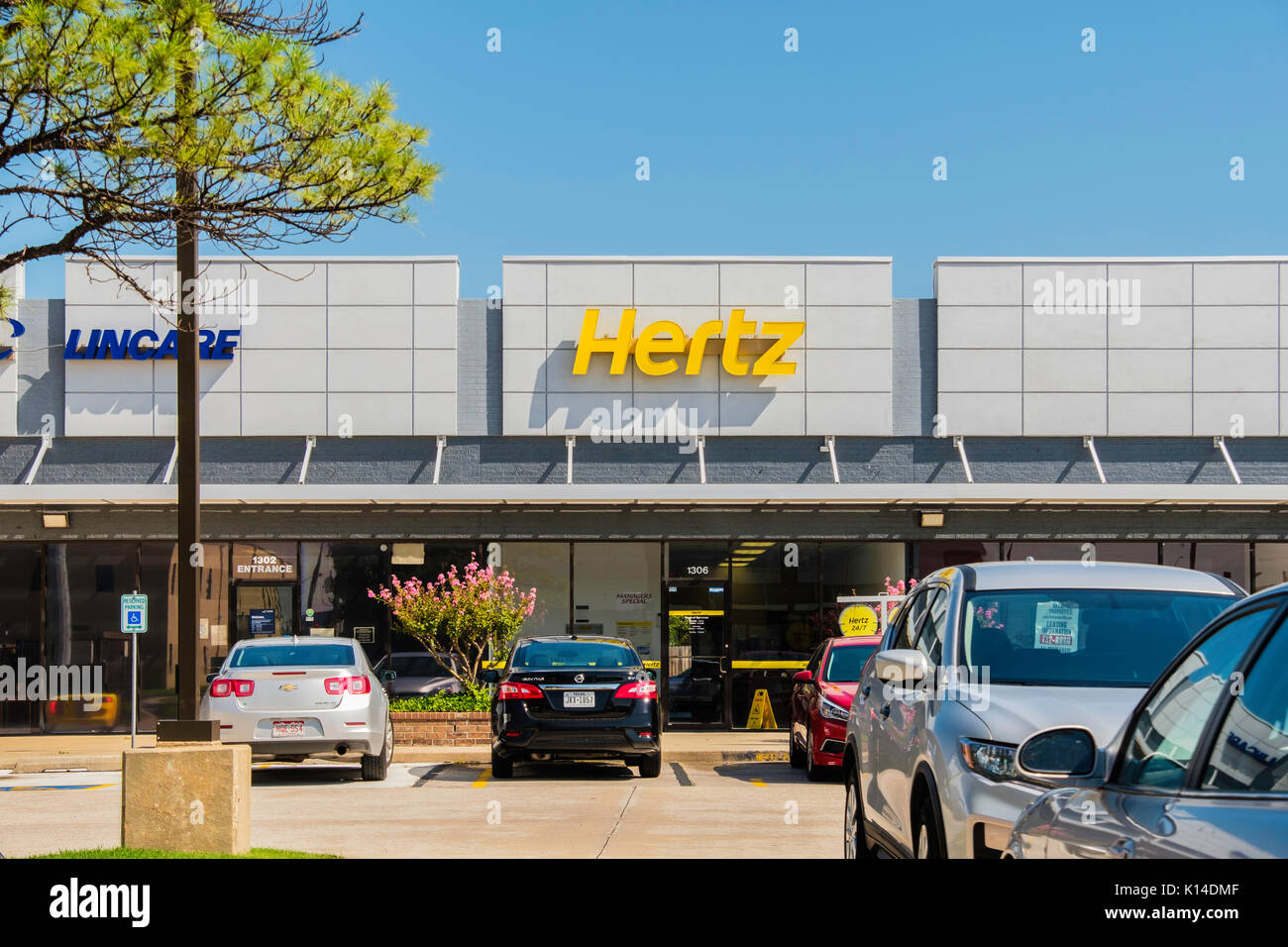 Exterior storefront of Hertz rent a car in a strip mall. Norman, Oklahoma, USA. Stock Photo