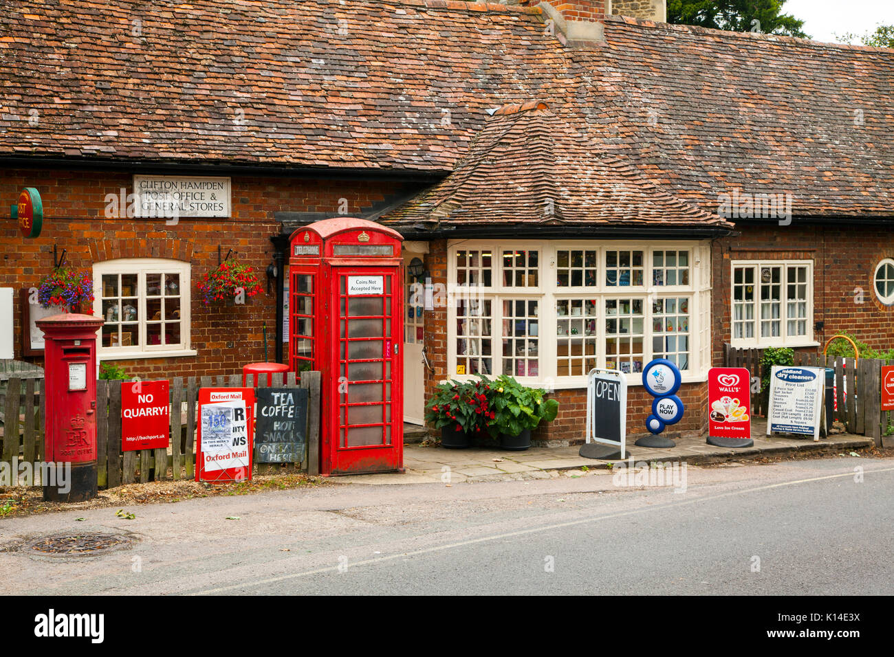 Clifton Hampden village post office and general stores in Oxfordshire with red phone box and red round post box outside now serving tea and coffee Stock Photo