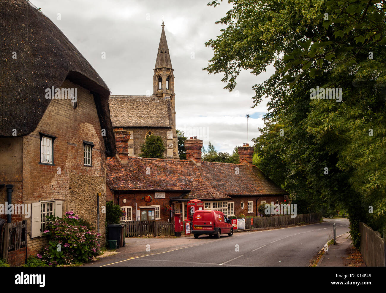 Clifton Hampden village post office and general stores in Oxfordshire with red phone box and red round post box outside now serving tea and coffee Stock Photo