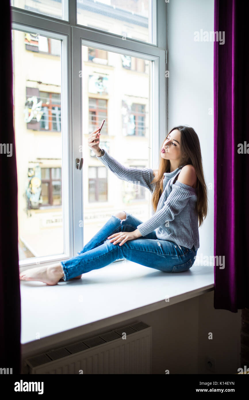beautiful girl in casual clothes doing selfie using a smartphone and ...