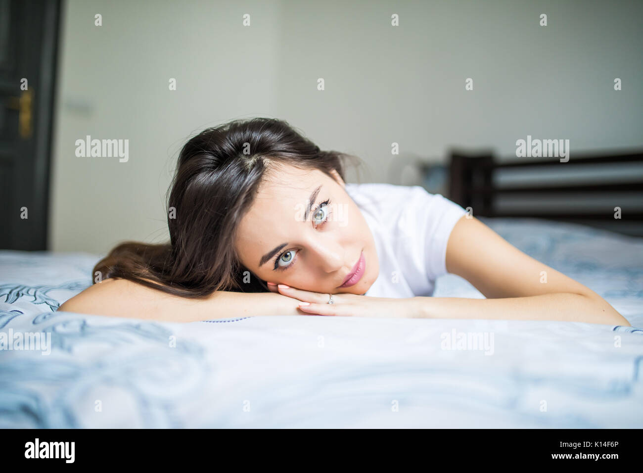 A woman lying on the bed and smiling Stock Photo - Alamy