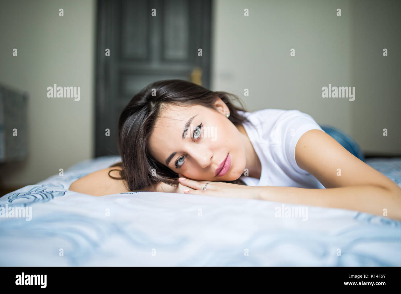 A woman lying on the bed and smiling Stock Photo - Alamy