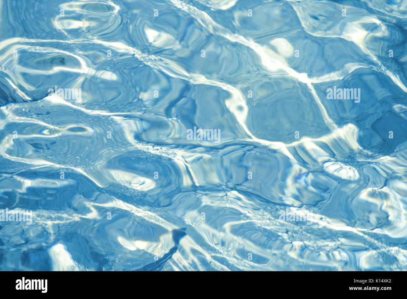 Shallow water over gravel bottom with reflections and small rippling waves Stock Photo
