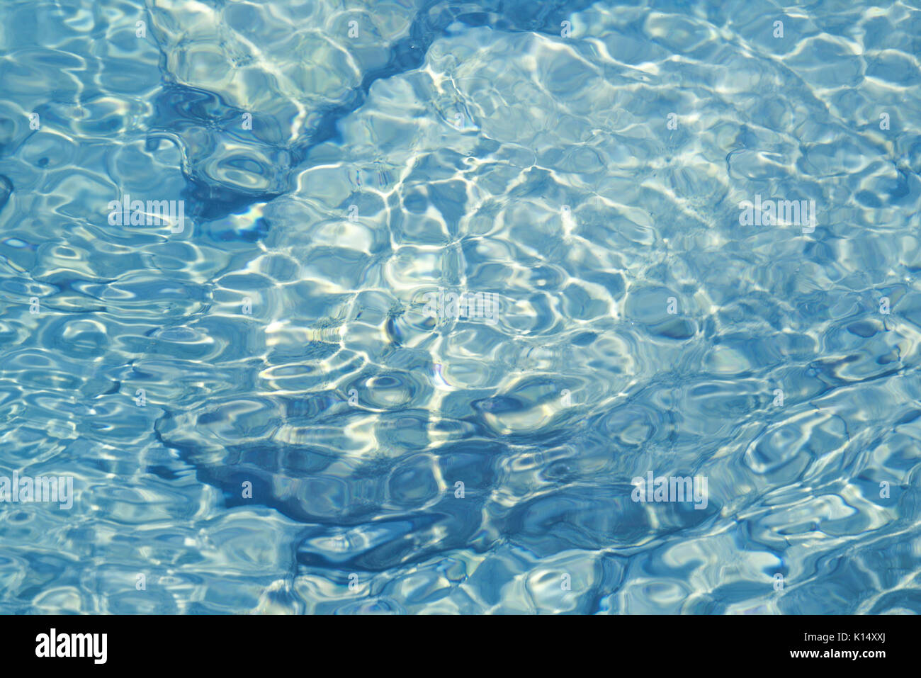 Shallow water over rocky bottom with reflections and small rippling waves Stock Photo