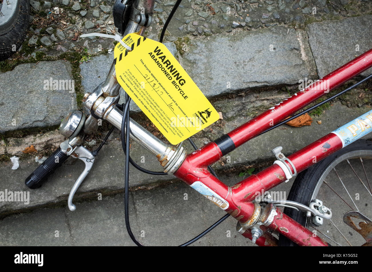 Abandoned Bike - label warning of impending removal of an abandoned bike in Cambridge UK Stock Photo