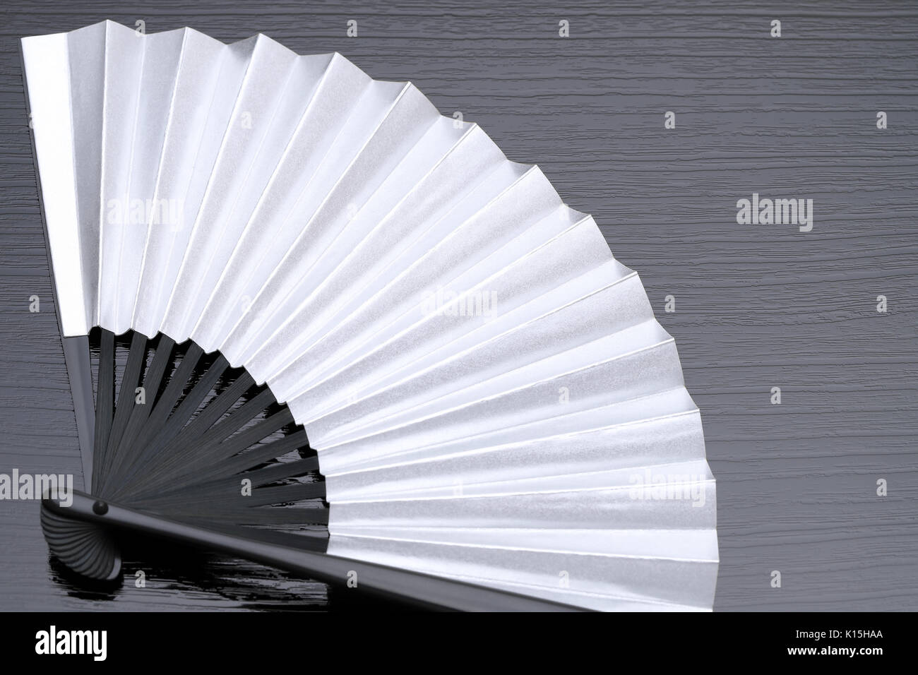 traditional japanese style silver hand fan on black background Stock Photo