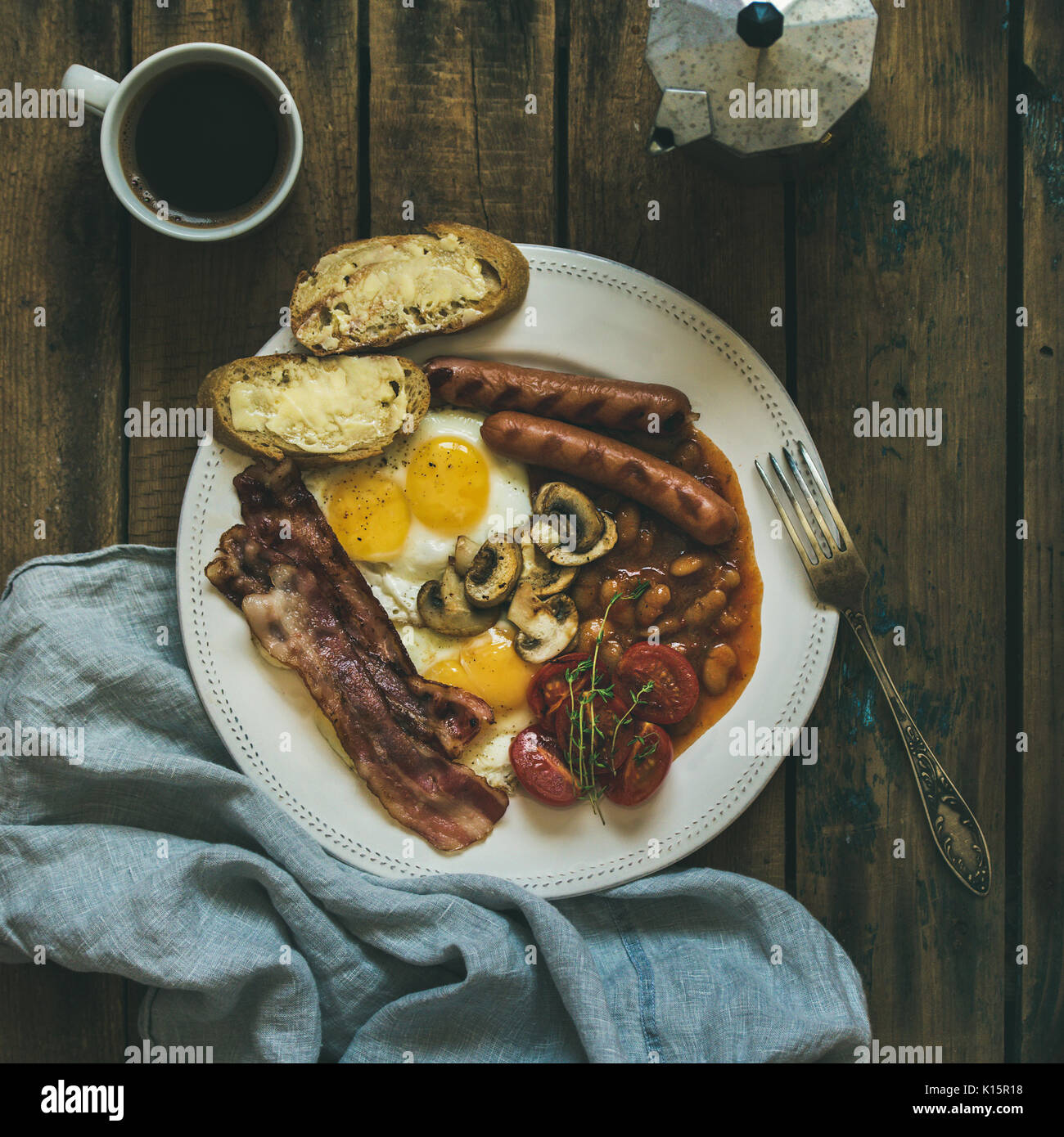 Traditional English breakfast with fried eggs, sausages, mushrooms