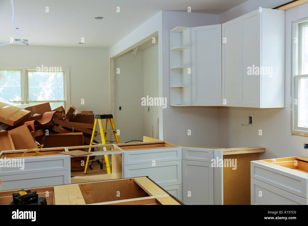Custom kitchen cabinets in various stages of installation Stock Photo