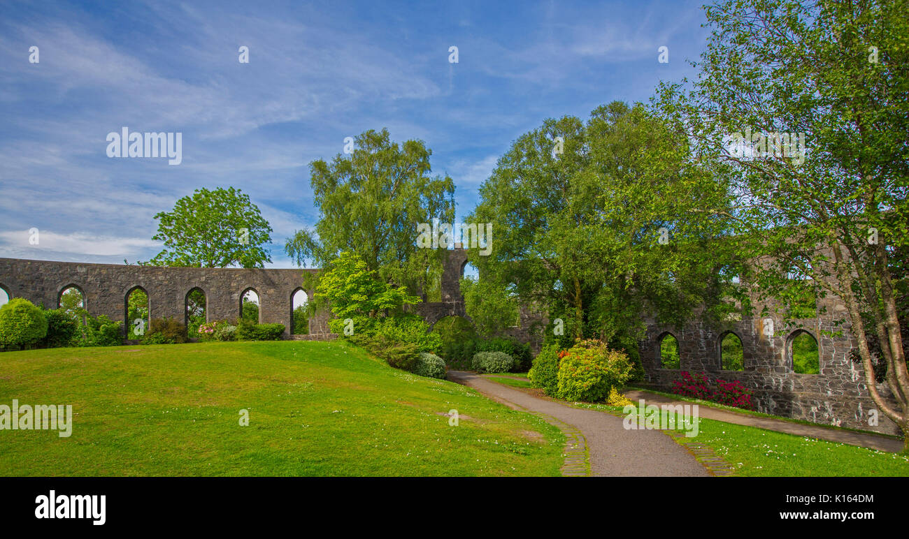 Panoramic view of section of historic McCaig's tower, unusual structure with arches in public park under blue sky at town of Oban, Scotland Stock Photo