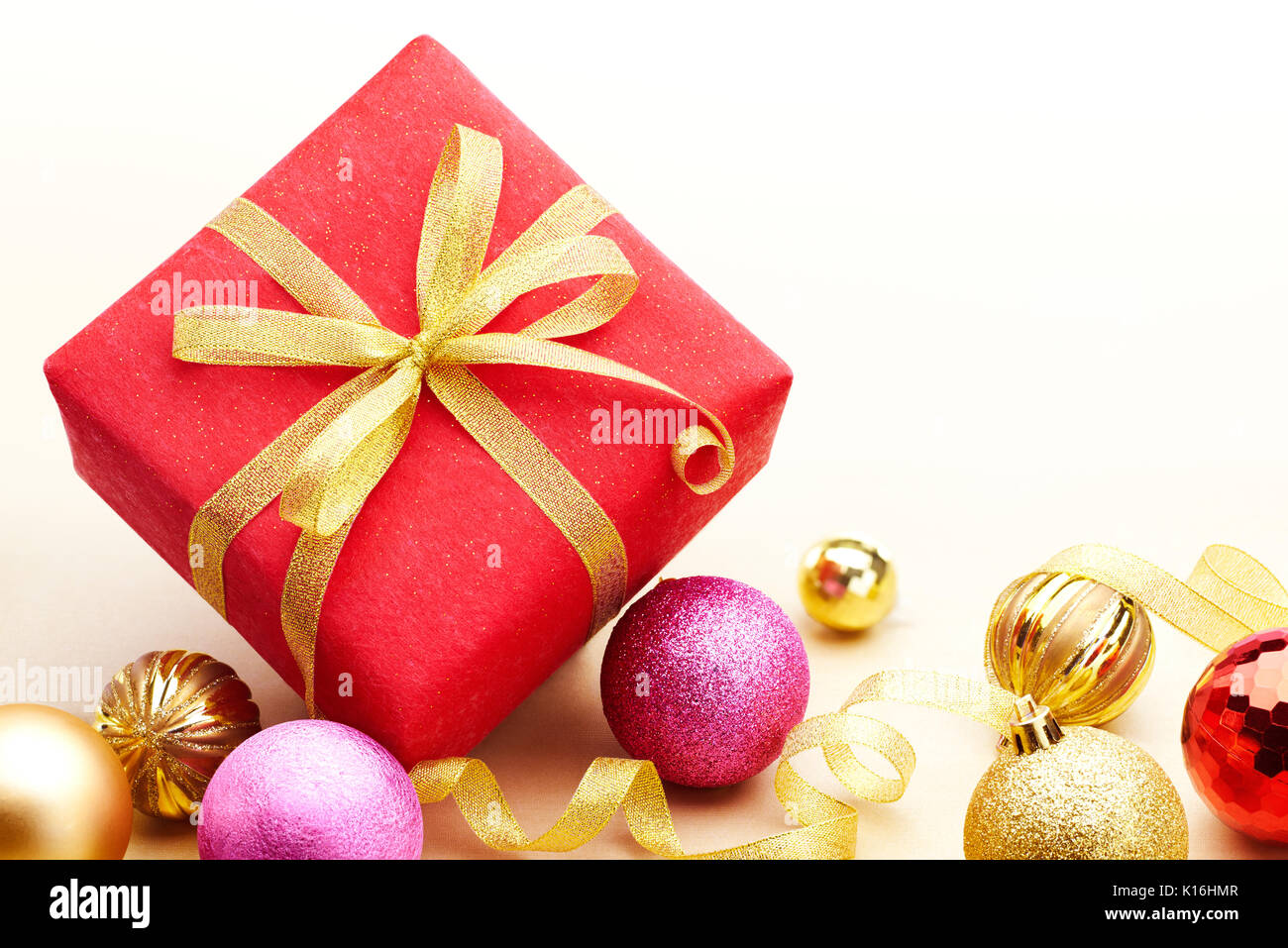 Christmas gift and baubles on gold color background Stock Photo