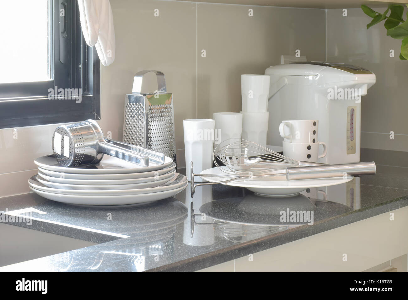 White ceramic set and stainless kitchen utensils on the counter Stock Photo