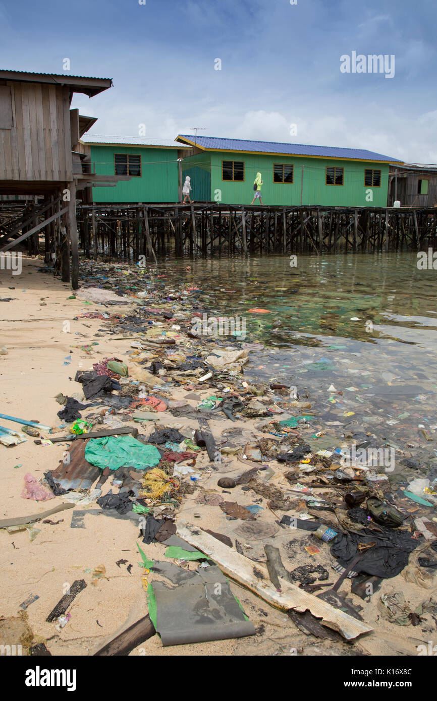Plastic trash and other garbage make for an ugly beach scene on Mabul Island, Borneo. The wooden