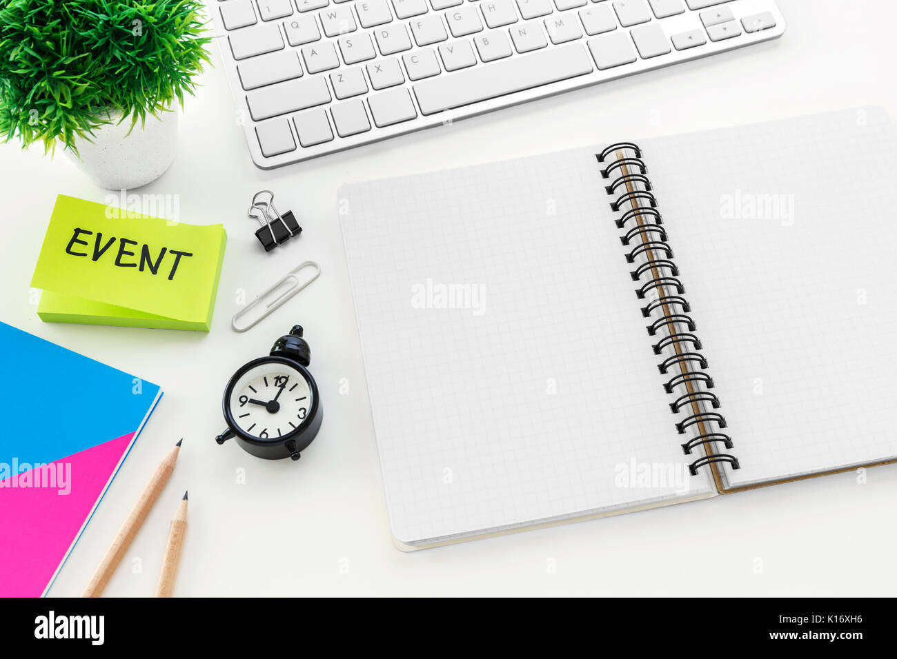 Blank notebook with on computer desk with pencil and clock for event planning concept Stock Photo