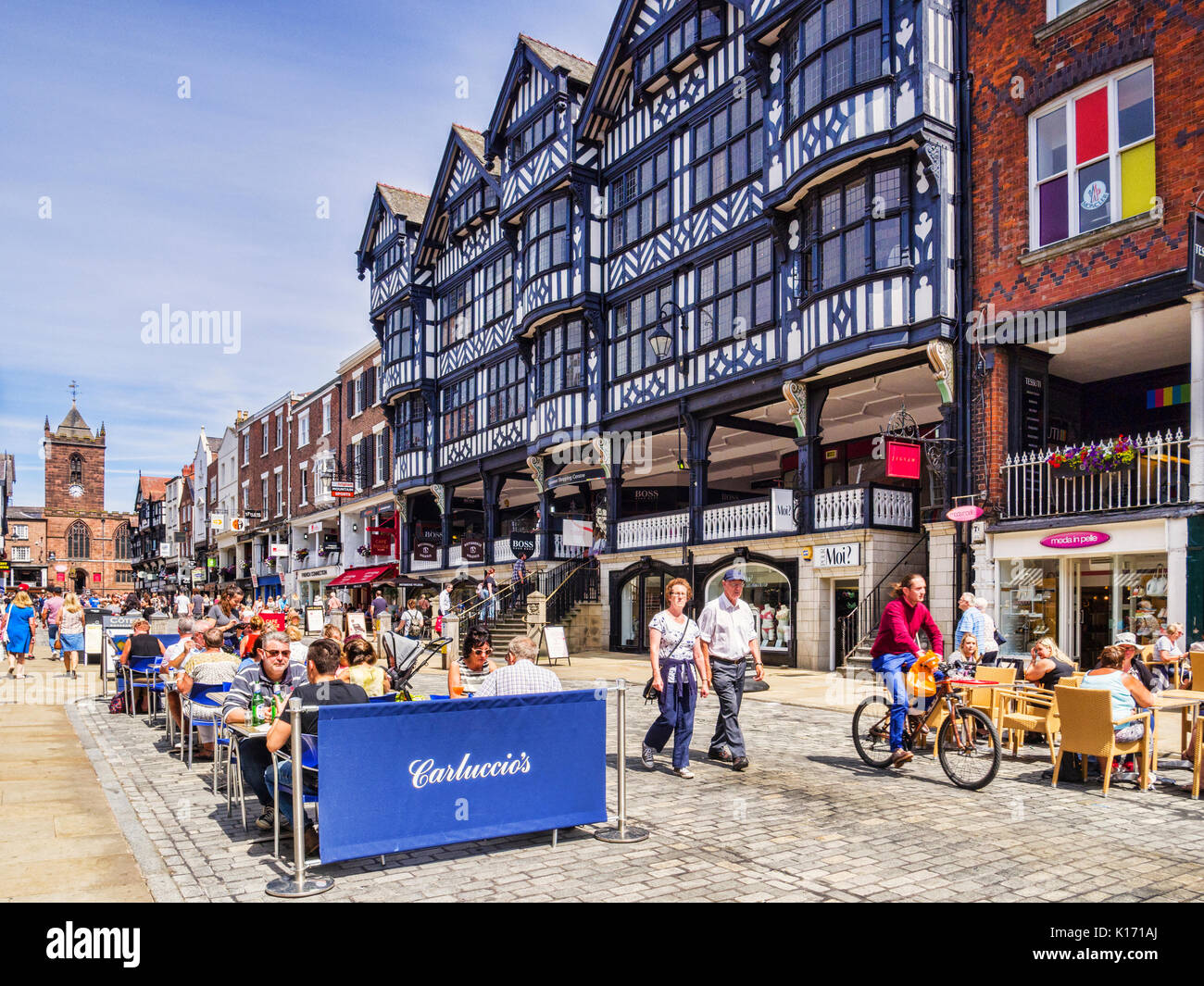 18 July 2017: Chester, Cheshire, England, UK - Half timbered houses in Bridge Street, and Carluccio's restaurant, with people sitting outside in the s Stock Photo