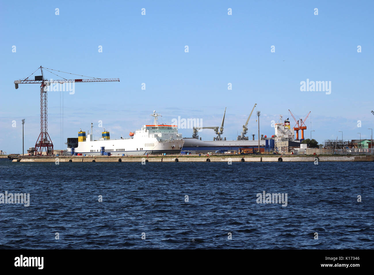 A cargo ship docked at the port of Dunkirk occupied to be loaded by cranes Stock Photo