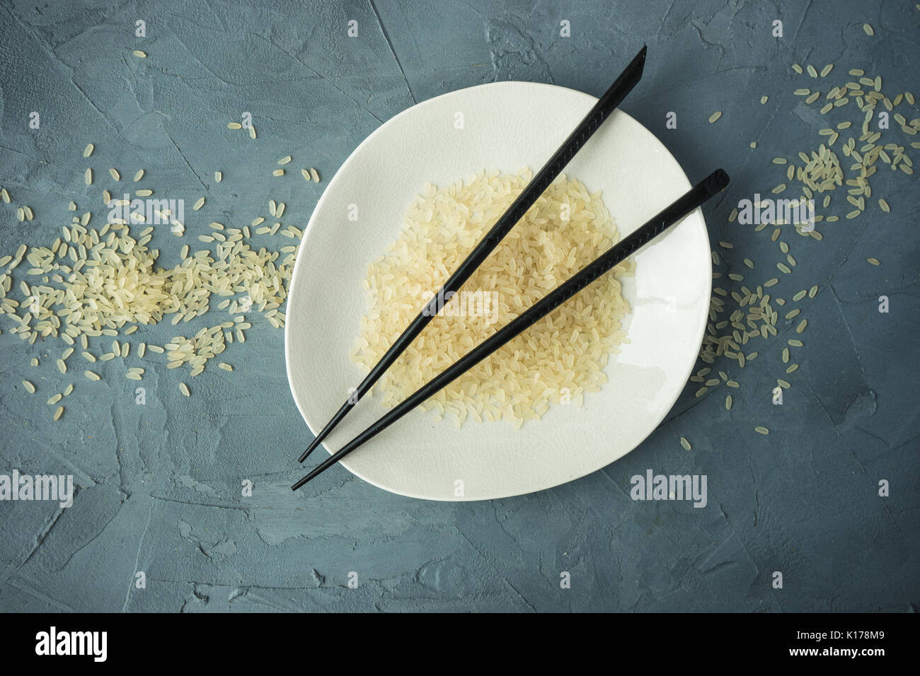Porcelain plate and rice on grey concrete table with copyspace Stock ...