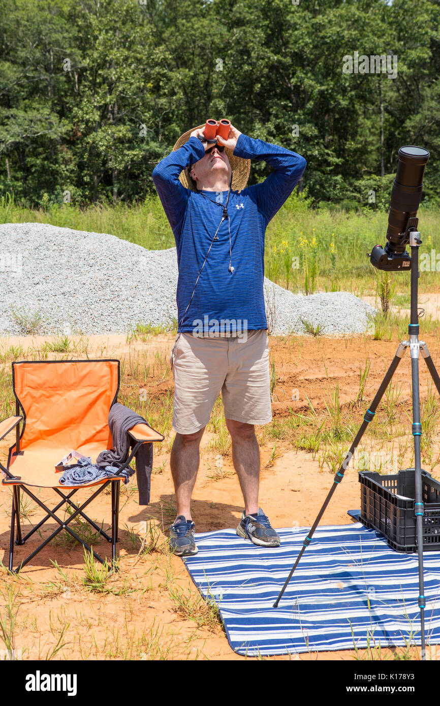A photographer with solar binoculars observes the Great American Eclipse on August 21, 2017. Stock Photo