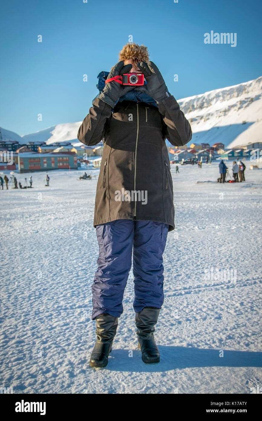 person standing on snow fully covered pointing a camera Stock Photo