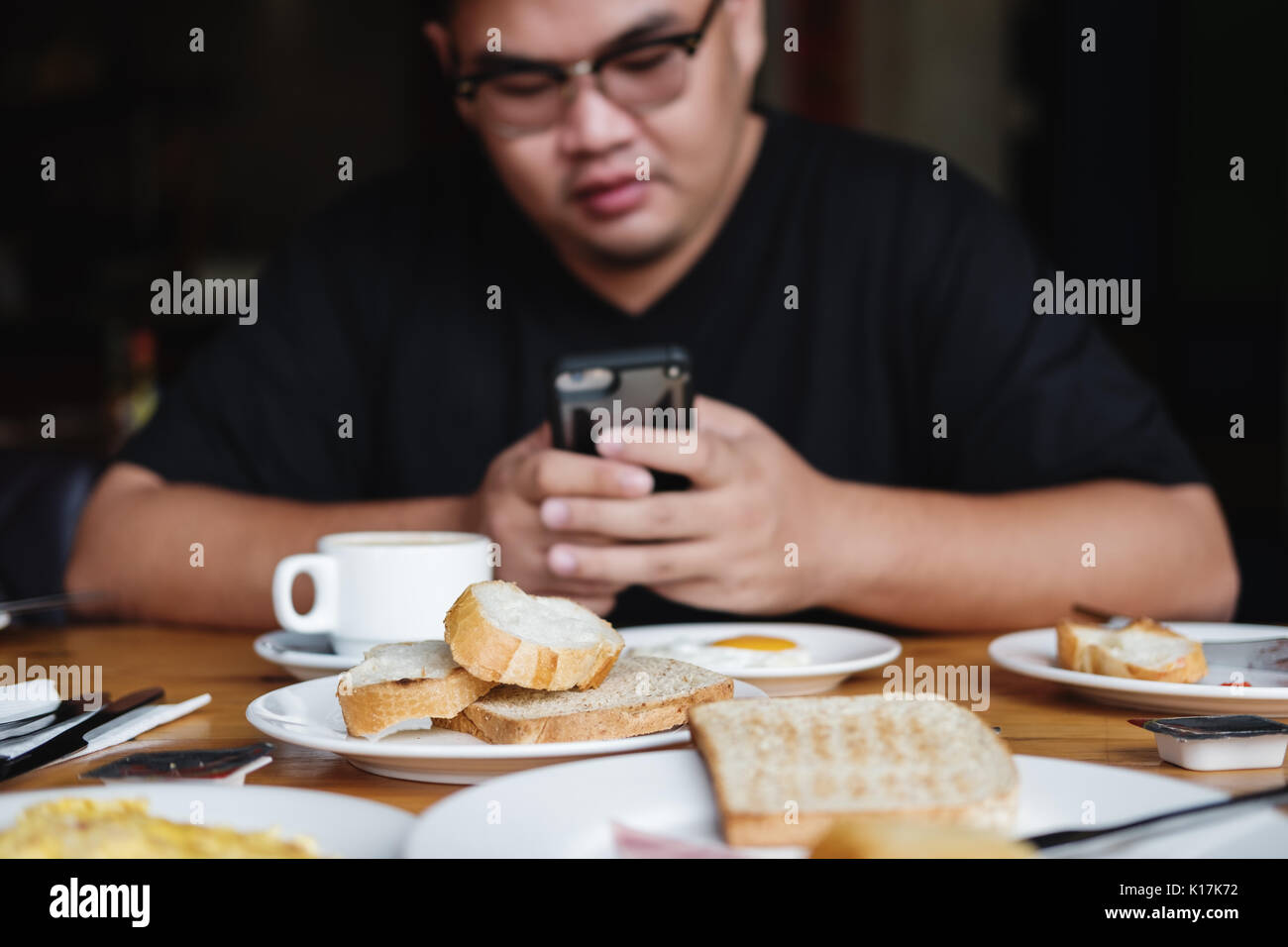 Morning meals, toasted breads with breakfast with defocus a man using mobile phone Stock Photo