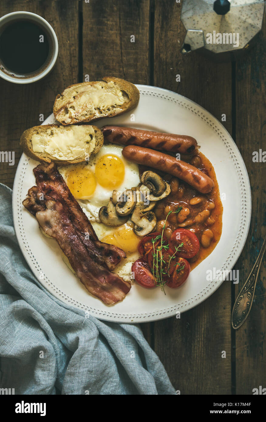English breakfast with fried eggs, sausages, mushrooms, bacon, beans