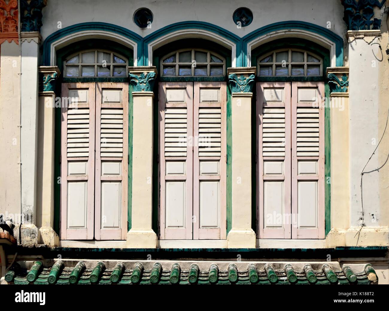 Traditional shop house exterior with pink wooden louvered shutters