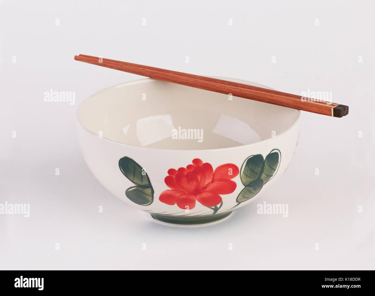 Hand painted ceramic soup bowl with wooden chopsticks isolated on white background Stock Photo