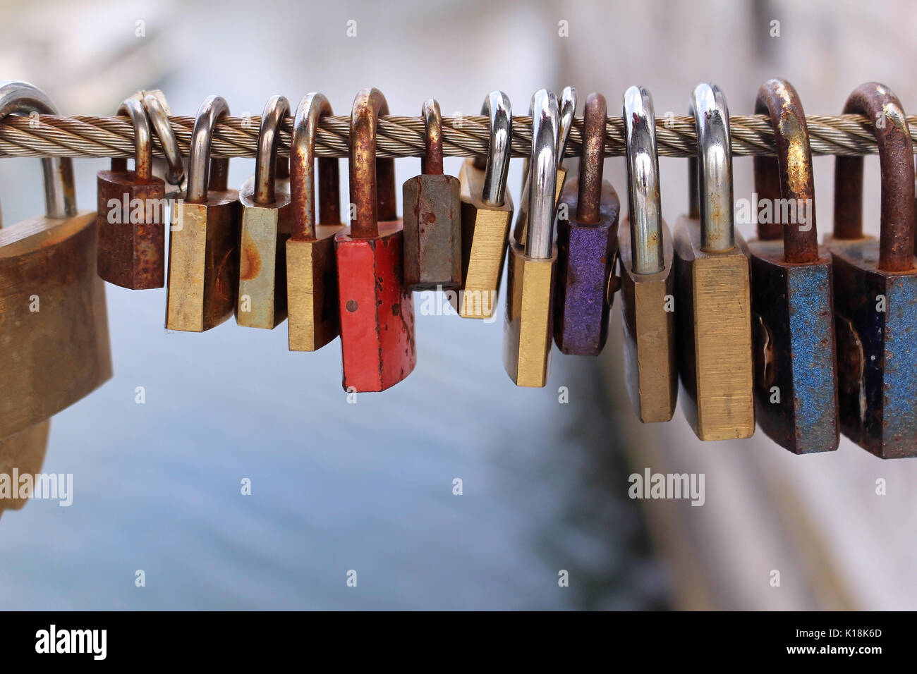 Old rusty padlocks left at the bridge fence as a symbol of eternal love ...