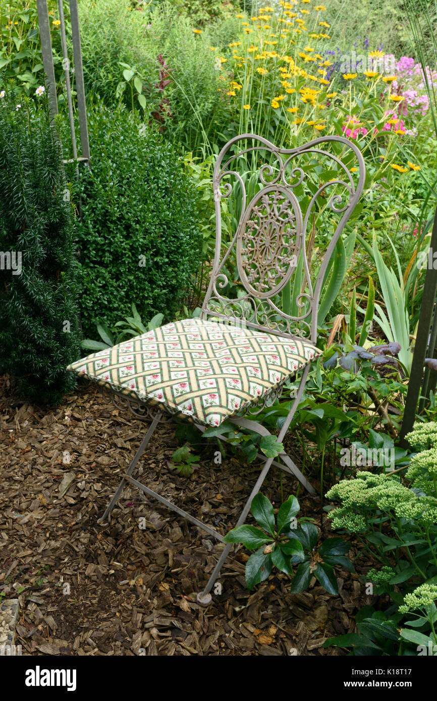 Garden chair in a perennial garden. Design: Marianne and Detlef Lüdke Stock Photo
