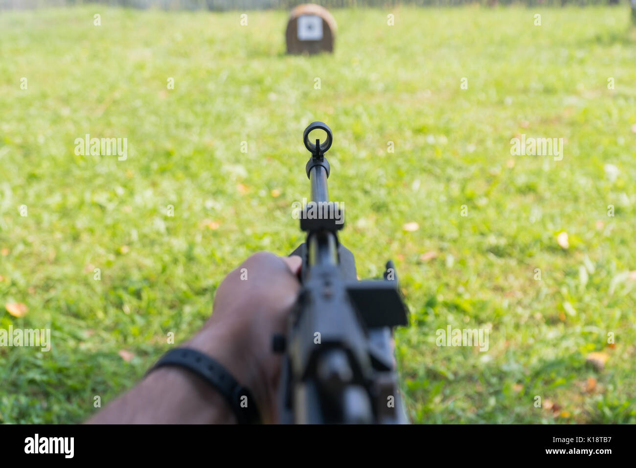 A man shoots a target from a pneumatic gun. A view from behind the ...
