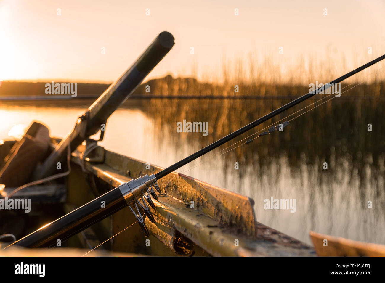 A broken fishing rod lies at the side of the boat at sunset Stock Photo -  Alamy