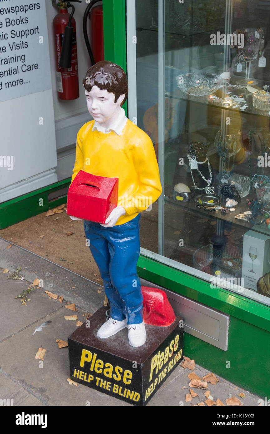 Please Help The Blind collection box and statue outside Prevention of Blindness Society Look Again Shop on Kensington High Street, London, UK Stock Photo