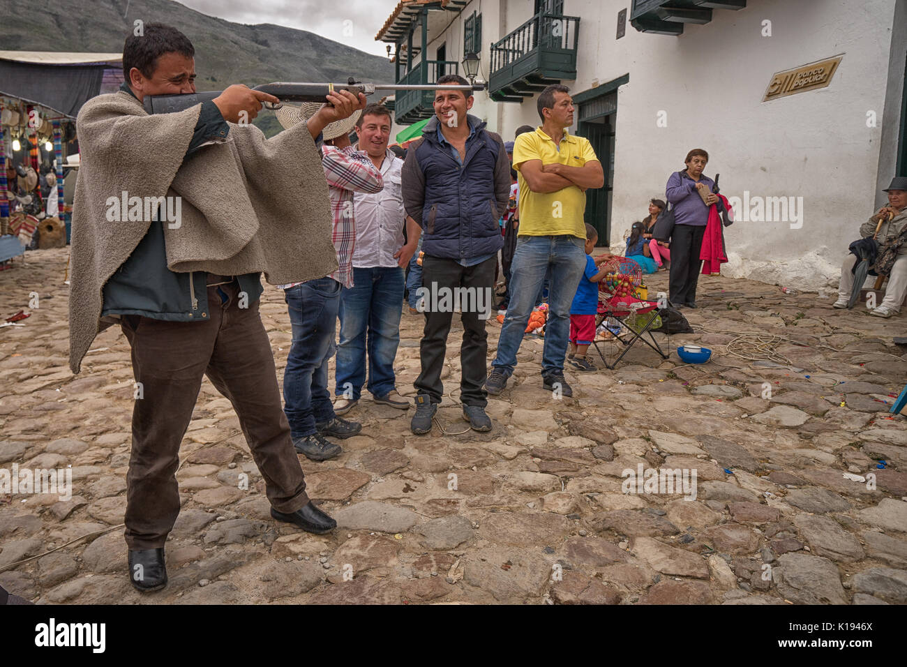 July 16, 2017 Villa de Leyva, Colombia: a local man wearing poncho aiming with a pellet gun during a fiesta Stock Photo