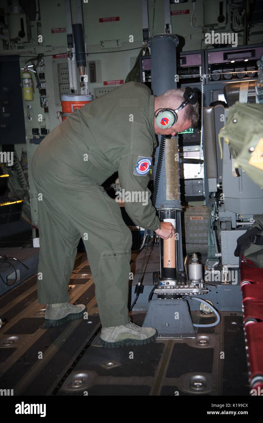 U.S. Air Force MSgt. Erik Marcus, 53rd Weather Reconnaissance Squadron loadmaster, loads a dropsonde for deployment into Hurricane Harvey from the Hurricane Hunters aircraft flying inside the hurricane August 24, 2017 over the Gulf of Mexico. A dropsonde collects data of the surrounding atmosphere that is remotely sent back to the aircraft by radio transmission. Hurricane Harvey is now a category 4 storm expected to hit the Texas coast causing major damage and flooding. Stock Photo