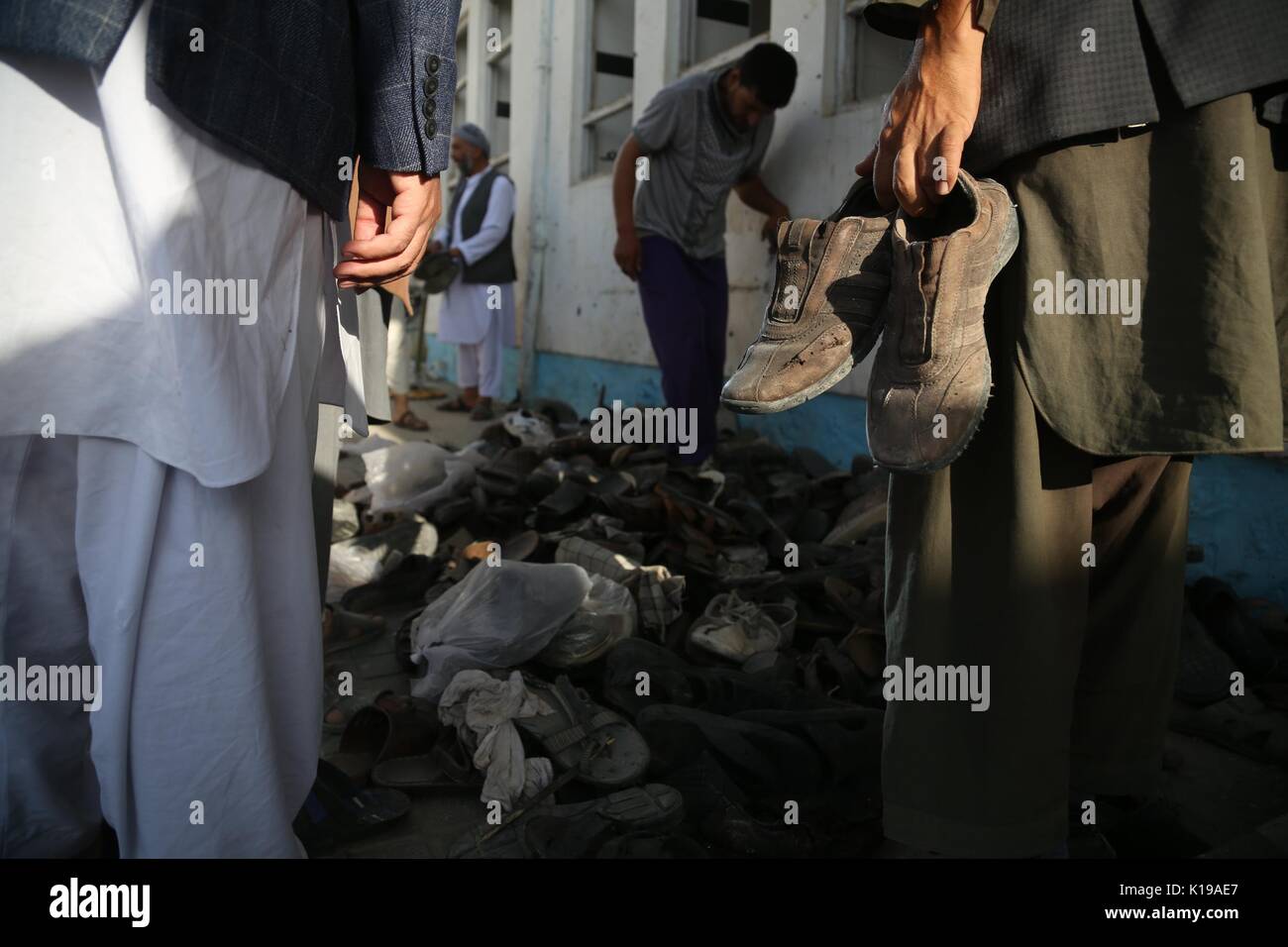Kabul, Afghanistan. 26th Aug, 2017. People search for shoes of relatives at the site of attack in Kabul, capital of Afghanistan, Aug. 26, 2017. The death toll of the mosque attack on Friday has risen to 40 while 90 people were wounded, the Afghan Independent Human Rights Commission said on Saturday. Credit: Rahmat Alizadah/Xinhua/Alamy Live News Stock Photo