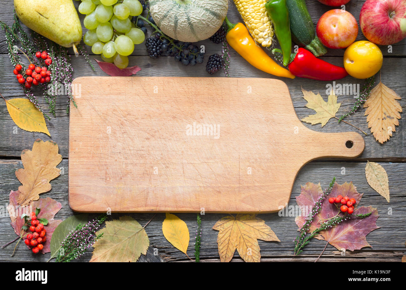 Autumn fruits and vegetables on a retro wooden background with leaves ...