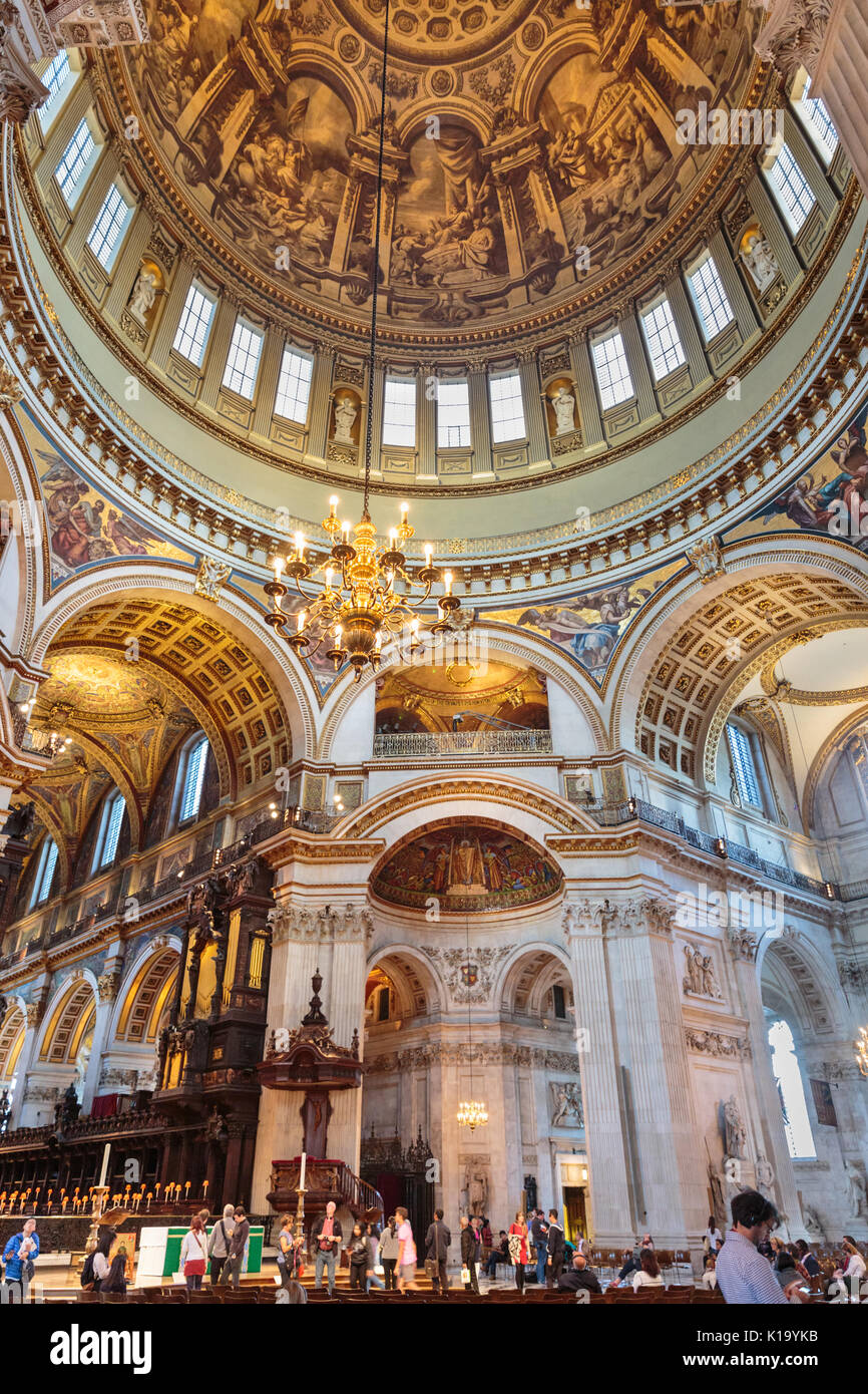 Tourists and visitors admire the interior and view up to the domed ceiling at St Paul's Cathedral, London UK Stock Photo