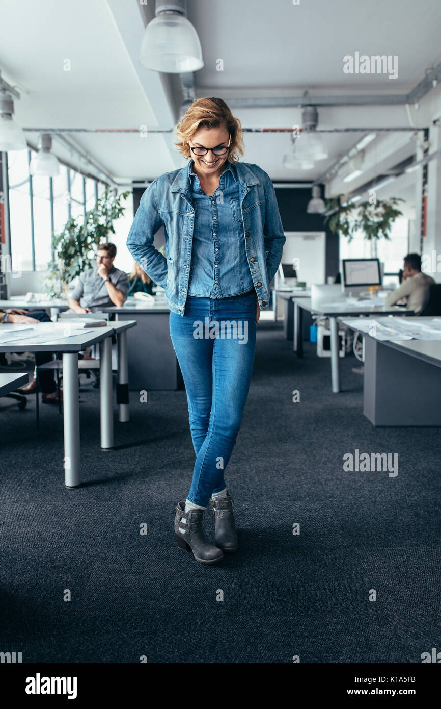 Woman crossed legs standing office hi-res stock photography and images ...