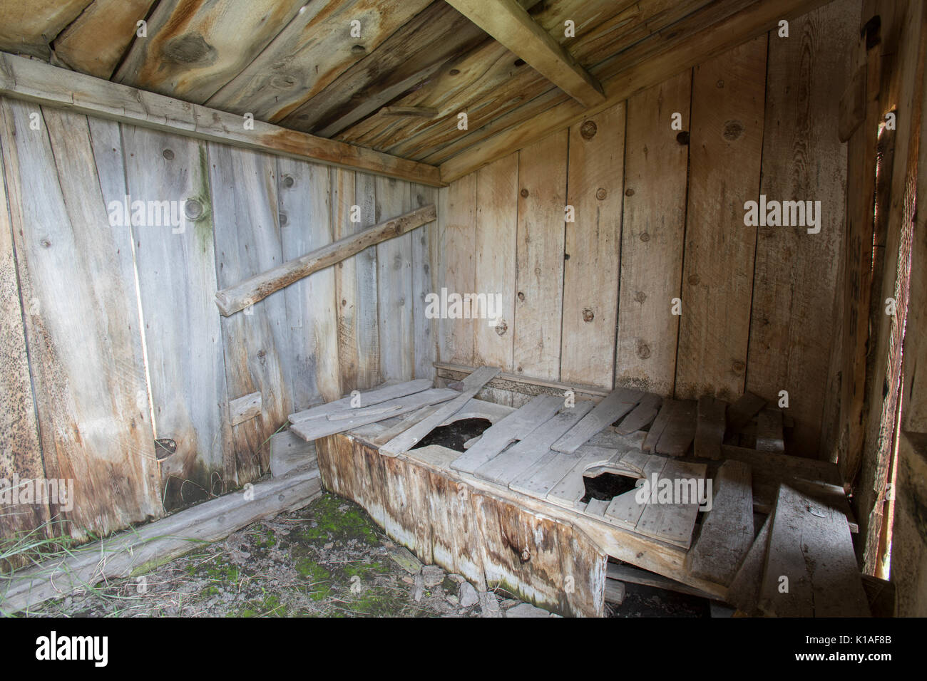 Interior of rustic outhouse with two seats in Bodie State Historic Park. Stock Photo