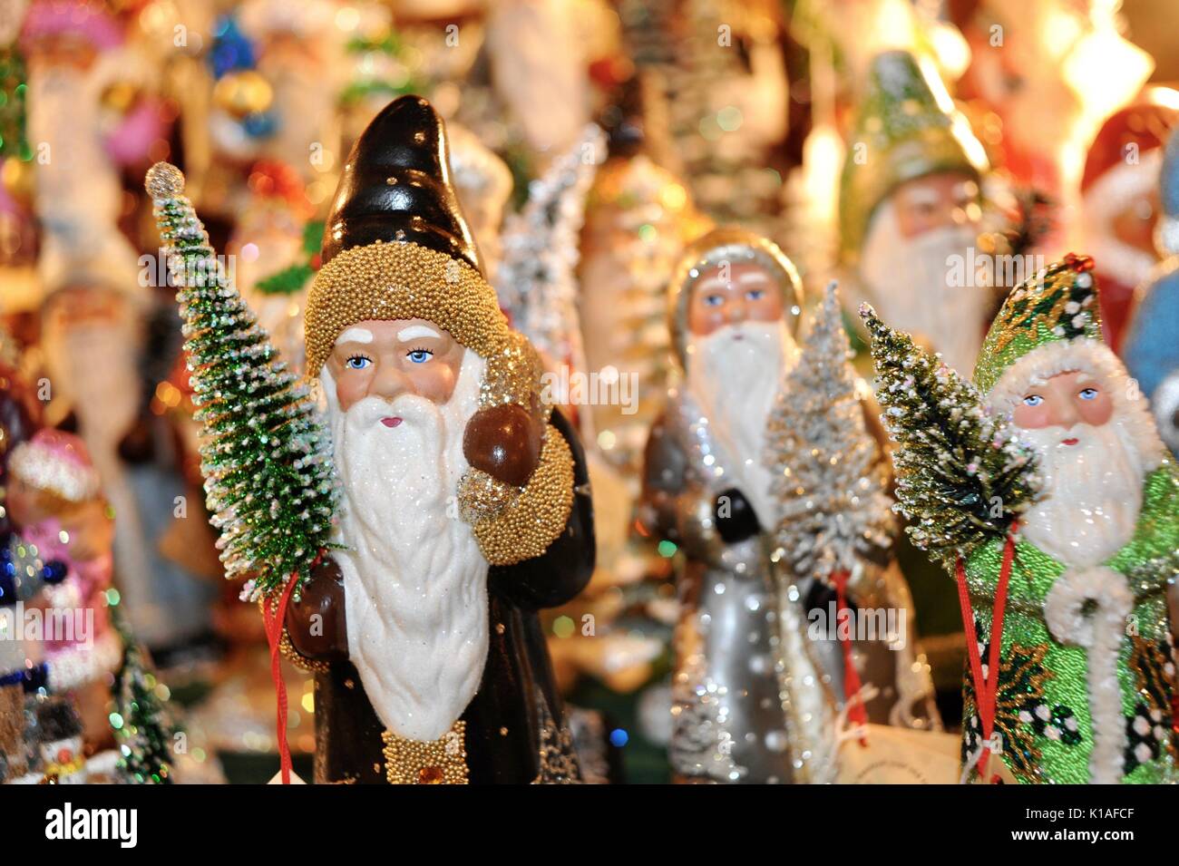 Close-up, hand-decorated European Father Christmas and Santa figurines/ornaments, holding Christmas tree at Old World Christmas Market Osthoff Resort. Stock Photo