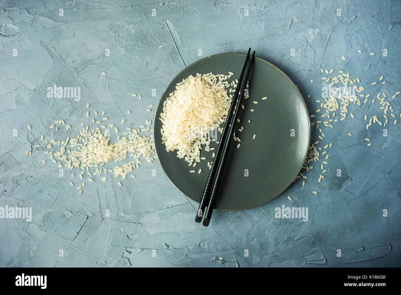 Porcelain plate and rice on grey concrete table with copyspace Stock ...