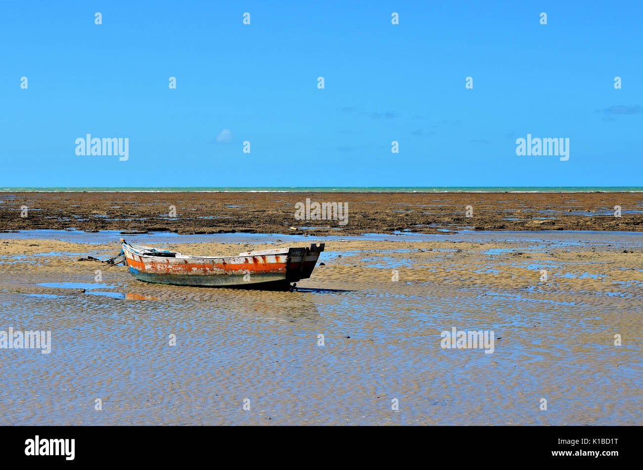 Small boat stranded during low tide with coral reef in the background in  Porto Seguro, Bahia, Brazil Stock Photo - Alamy