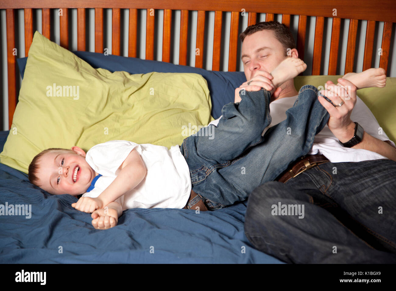 father tickling son at home Stock Photo