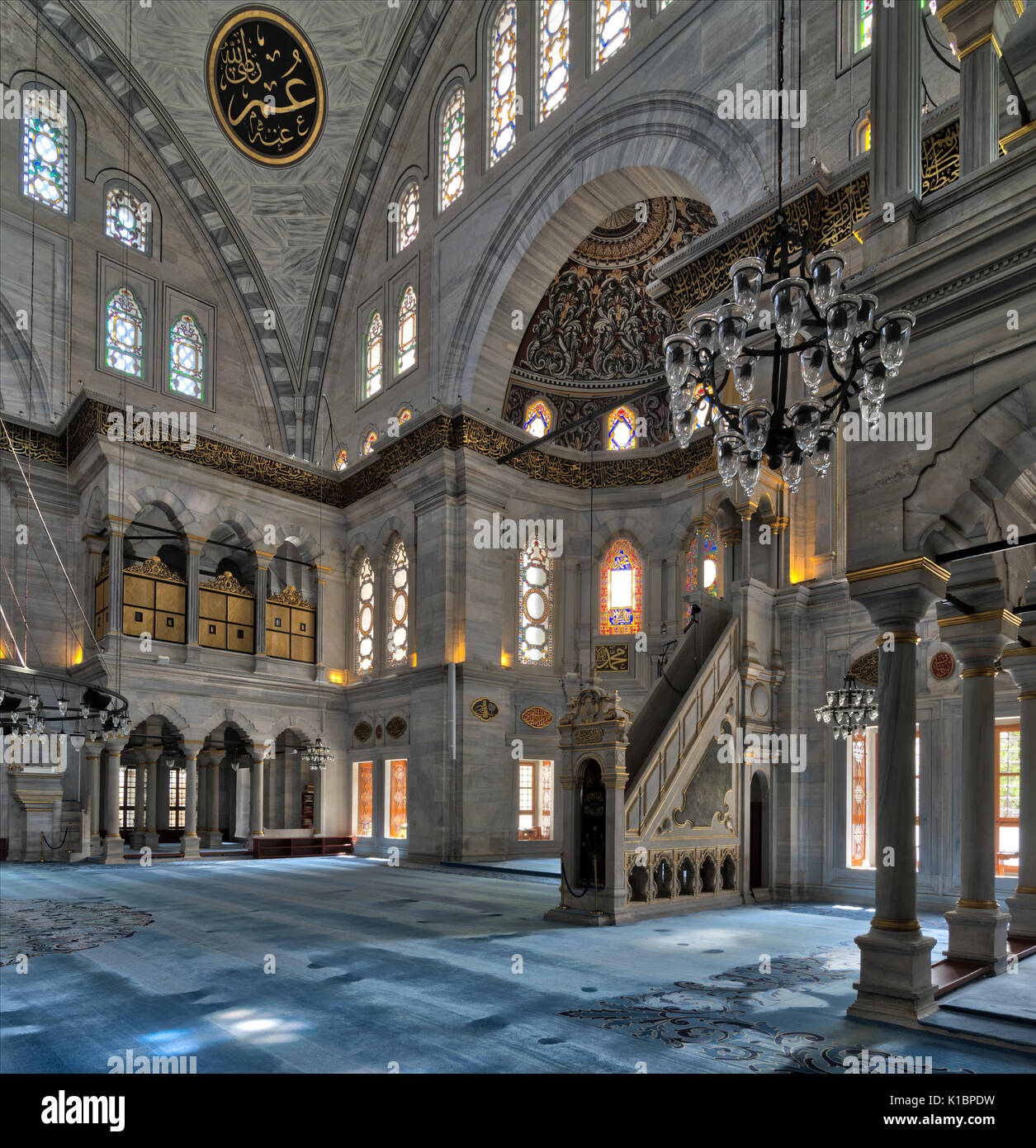 Interior shot of Nuruosmaniye Mosque, an Ottoman Baroque style mosque with minbar (platform), huge arches & colored stained glass windows located in S Stock Photo