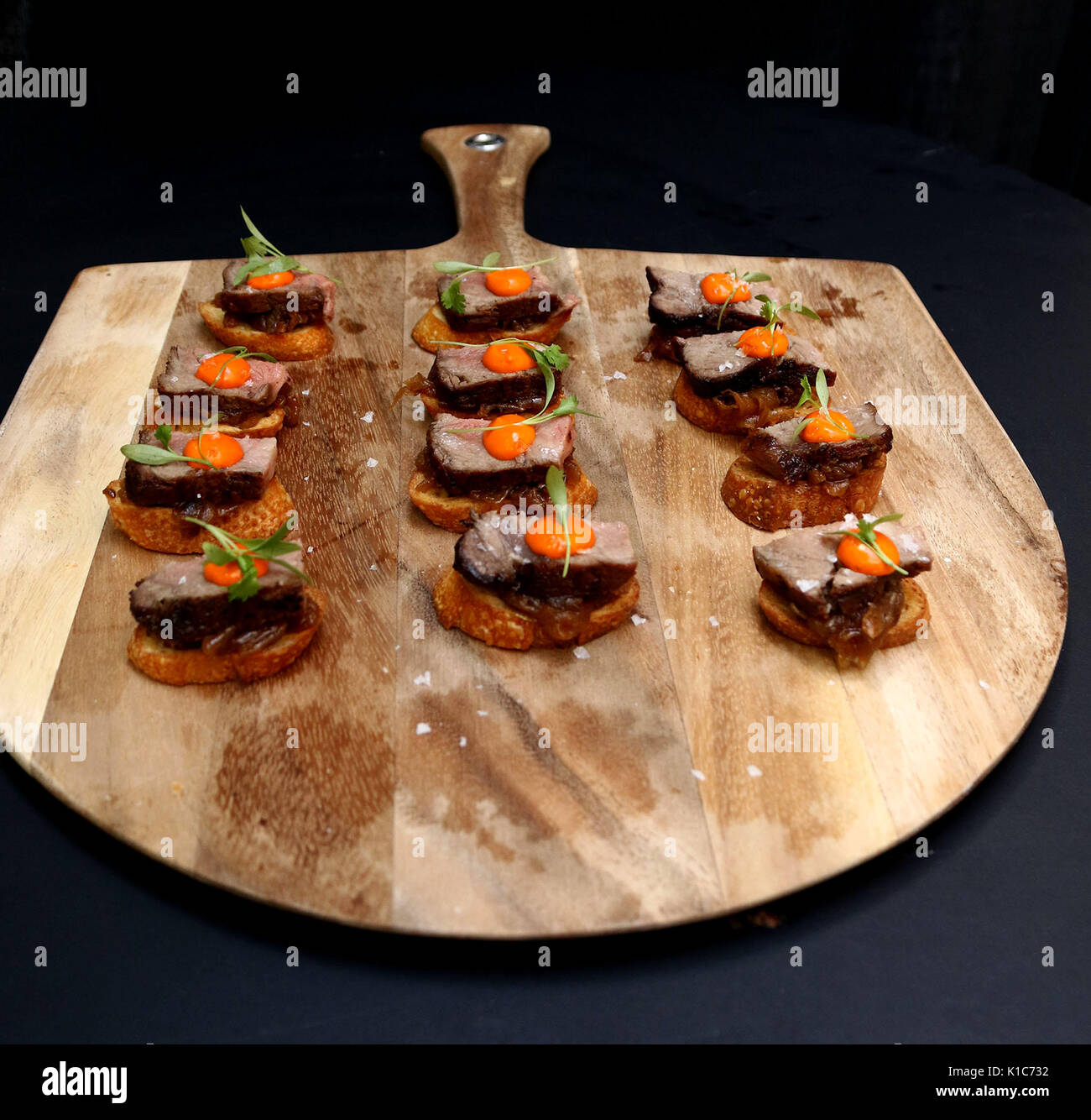 Wooden carving board with beef tenderloin with egg yolk hors d'oeuvres